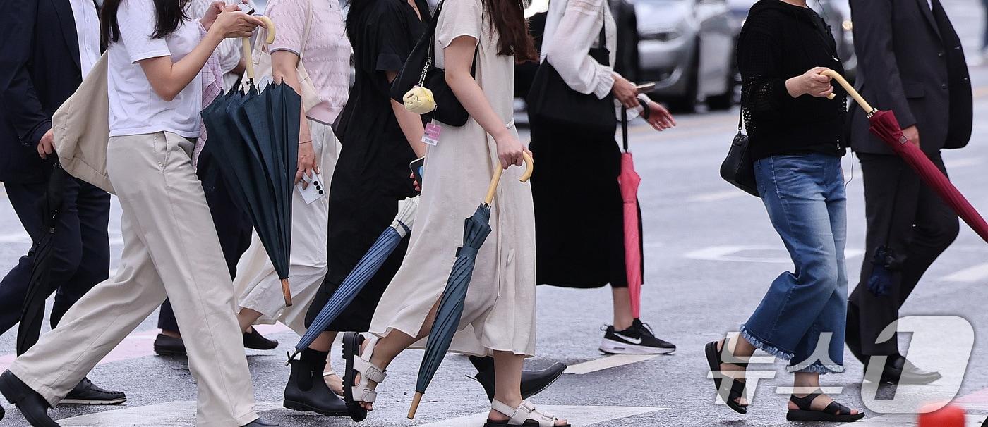 본문 이미지 - 7일 서울 광화문네거리에서 출근하는 시민들이 비가 내렸다 그치기를 반복하는 날씨 속에 우산을 손에 든 채 발걸음을 옮기고 있다. 장마철이지만 정체전선이 뚜렷하게 형성되지 않으면서 내륙 곳곳에서는 국지적으로 비가 오락가락하는 날씨가 이어지고 있다. 2026.7.7 ⓒ 뉴스1 박지혜 기자