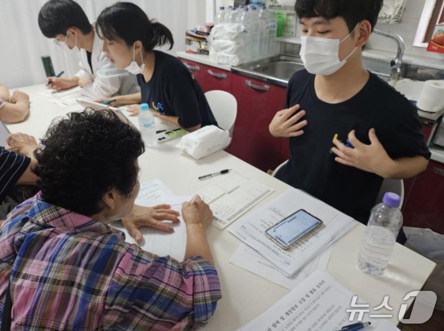 본문 이미지 - '농심천심 국민참여단' 의료봉사에 나선 대구한의대 학생이 대구 군위군 상곡리 마을회관에 마련된 간이 진료소를 찾은 어르신의 건강 상태를 상담하고 있다.(대구농협 제공, 재판매 및 DB 금지)