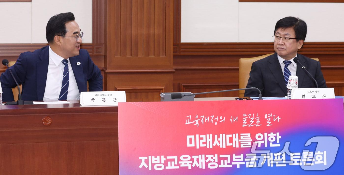본문 이미지 - 박홍근 기획예산처 장관과 최교진 교육부 장관이 8일 서울 종로구 세종대로 정부서울청사에서 열린 미래세대를 위한 지방교육재정교부금 개편 토론회에서 대화를 하고 있다. 2026.7.8 ⓒ 뉴스1 김명섭 기자