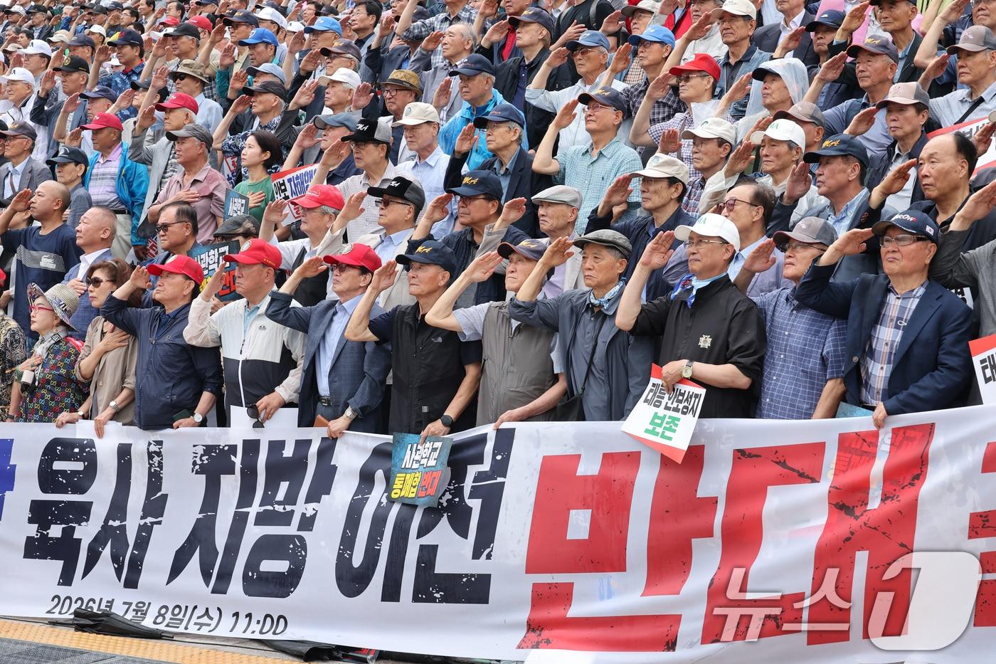 본문 이미지 - 육군·해군·공군사관학교 총동창회 회원들이 8일 서울 여의도 국회 본관 앞에서 열린 사관학교 통폐합 반대 궐기대회에서 국기에 대한 경례를 하고 있다. 2026.7.8 ⓒ 뉴스1 신웅수 기자