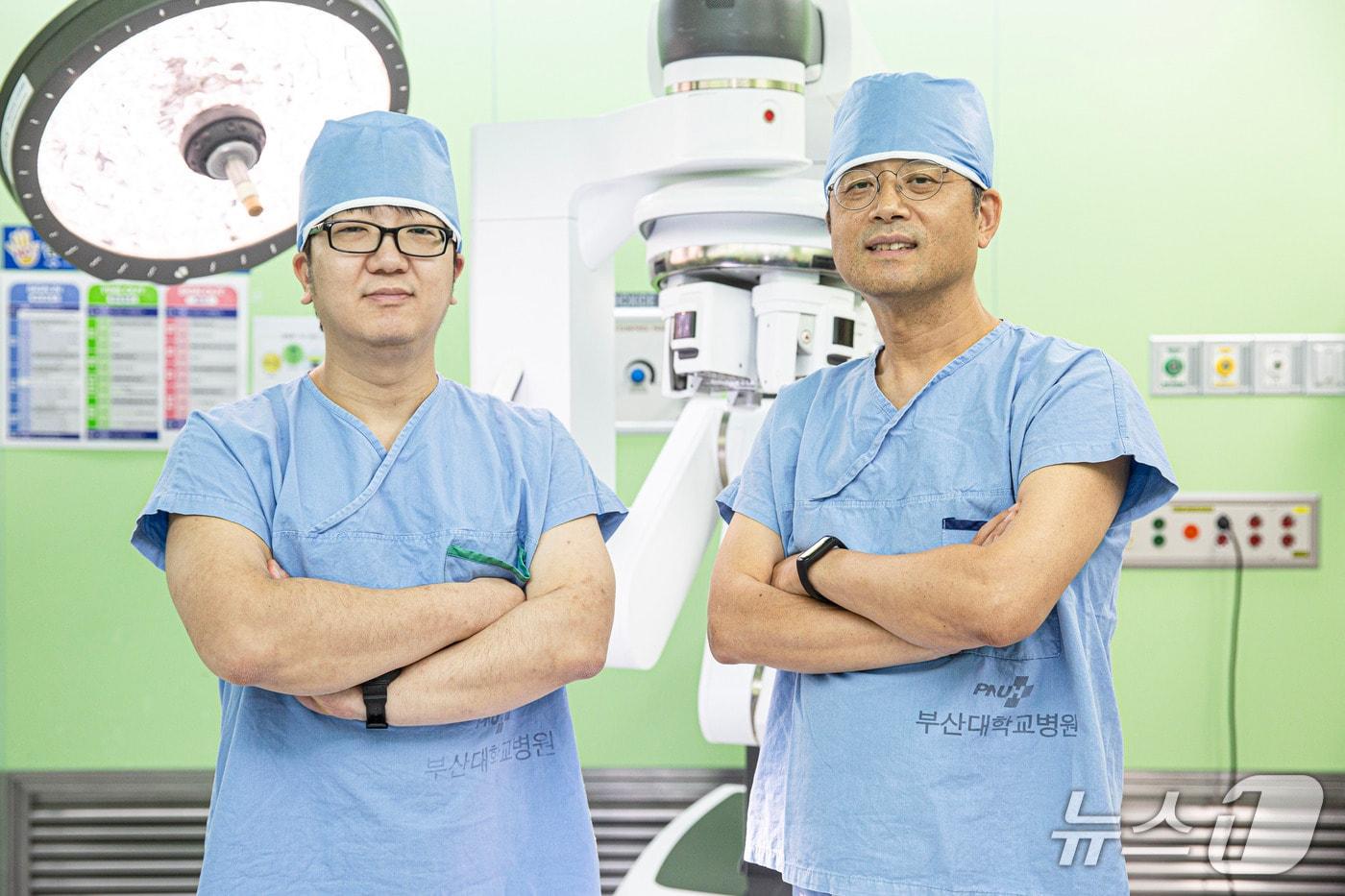 본문 이미지 - 부산대병원 비뇨의학과 신동길 교수(오른쪽)와 김현우 교수가 다빈치 로봇수술기 앞에서 사진 촬영을 하고 있다.(부산대병원 제공. 재판매 및 DB금지)