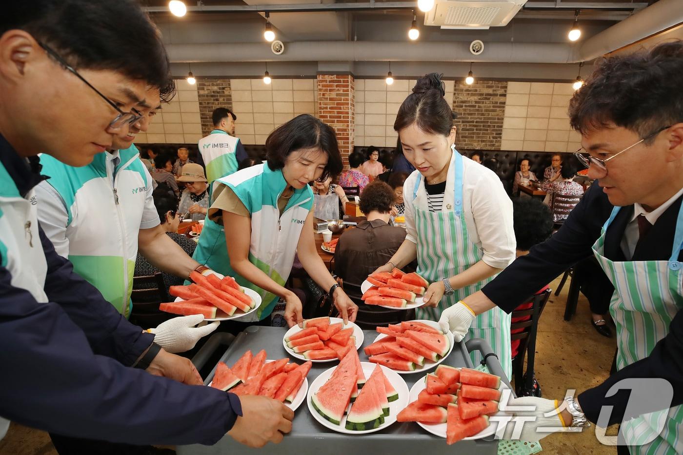 본문 이미지 - 9일 대구 중구 한 음식점에서 열린 '초복맞이 영양식 나눔' 행사에서 중구의회 의원, 남산종합사회복지관, iM뱅크사회공헌재단 관계자들이 어르신께 갈비탕과 육회비빔밥, 수박 등 복달임 음식을 대접하고 있다. 대구 중구는 삼복더위 기간 관내 30여 개 경로당과 복지관 어르신을 위한 보양식 나눔 행사를 마련한다. 2026.7.9 ⓒ 뉴스1 공정식 기자