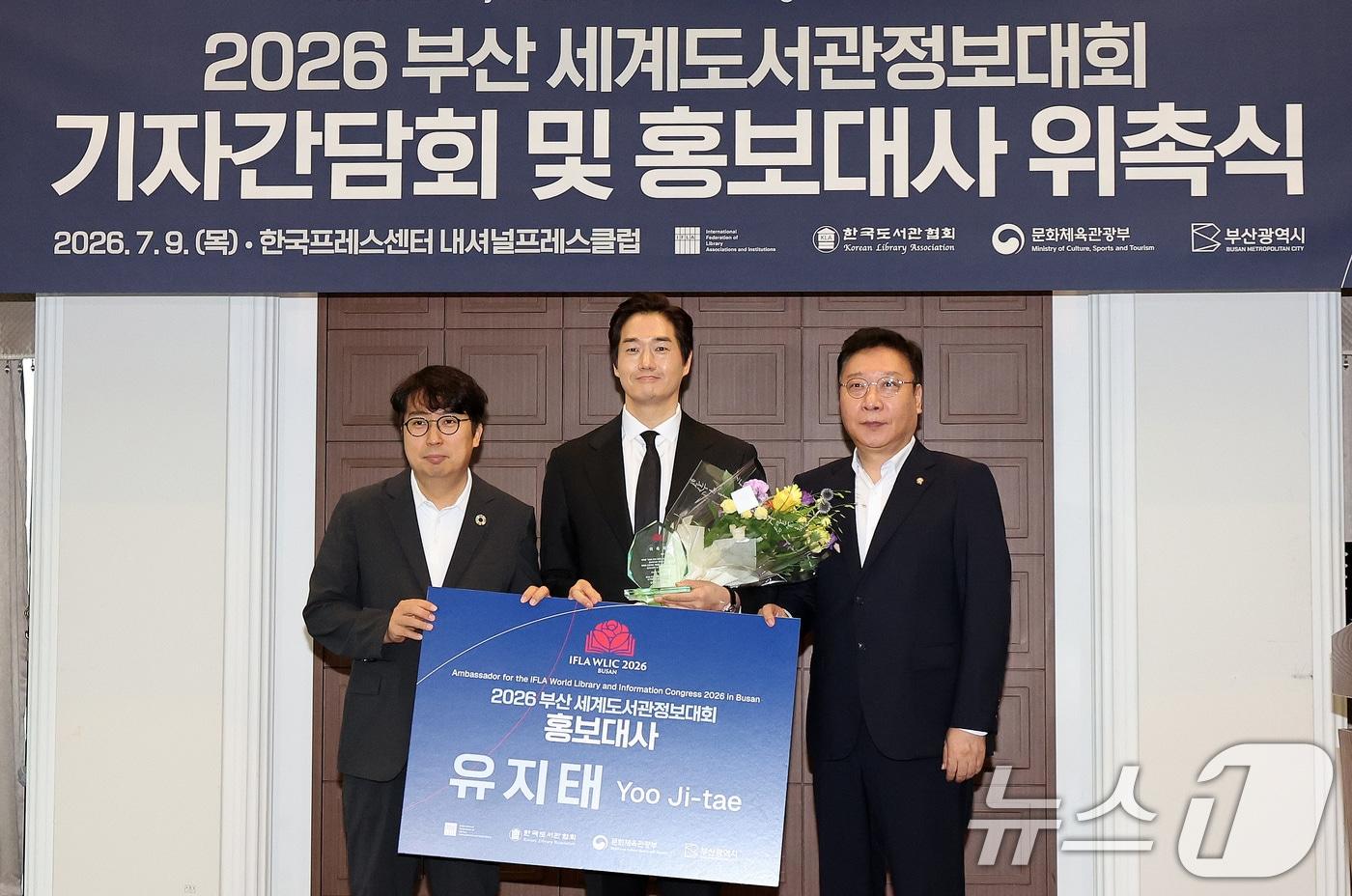 본문 이미지 - 9일 서울 중구 프레스센터에서 열린 2026 부산세계도서관정보대회(WLIC) 기자간담회 및 홍보대사 위촉식에서 정연욱, 차지호 공동조직위원장이 홍보대사 배우 유지태와 기념촬영을 하고 있다. 2026.7.9 ⓒ 뉴스1 박지혜 기자