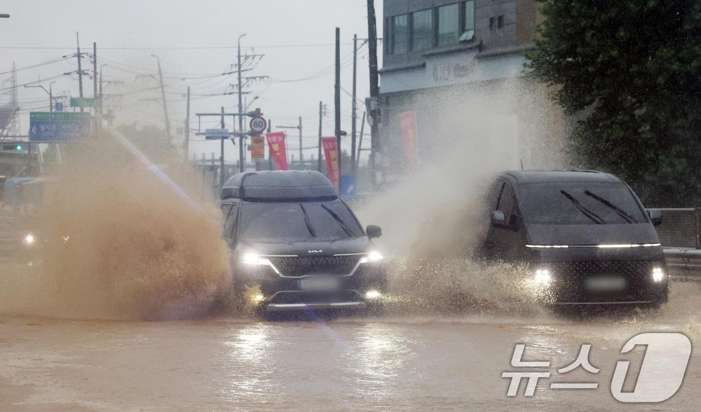 본문 이미지 - 수도권에 많은 비가 내린 9일 경기 오산시의 한 도로가 침수돼 차량이 물보라를 일으키며 주행하고 있다. 2026.7.9 ⓒ 뉴스1 김영운 기자