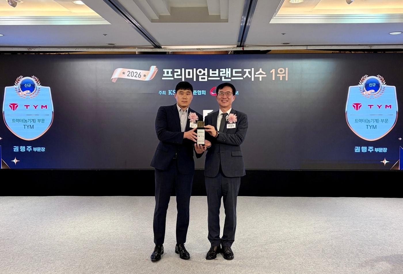 본문 이미지 - TYM이 '2026 프리미엄브랜드지수(KS-PBI)' 트랙터 부문 1위에 선정됐다. 사진은 권행주 TYM 상품기획부문장(왼쪽)과 문동민 한국표준협회 회장이 기념촬영을 하는 모습. (TYM 제공)