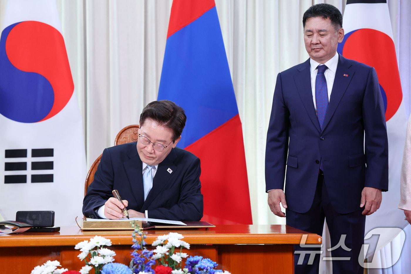 본문 이미지 - 몽골을 국빈 방문 중인 이재명 대통령이 9일(현지시간) 울란바타르 정부청사에서 방명록에 서명하고 있다. 오른쪽은 오흐나 후렐수흐 몽골 대통령. 2026.7.9 ⓒ 뉴스1 이재명 기자