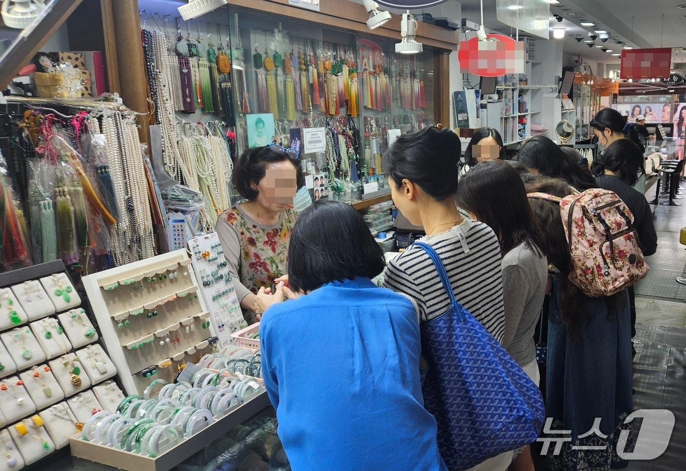 본문 이미지 - 서울 종로구 귀금속거리의 한 옥 전문 매장을 찾은 손님들이 옥반지와 옥팔찌를 구경하는 모습. 2026.7.9 ⓒ 뉴스1 윤지오 기자
