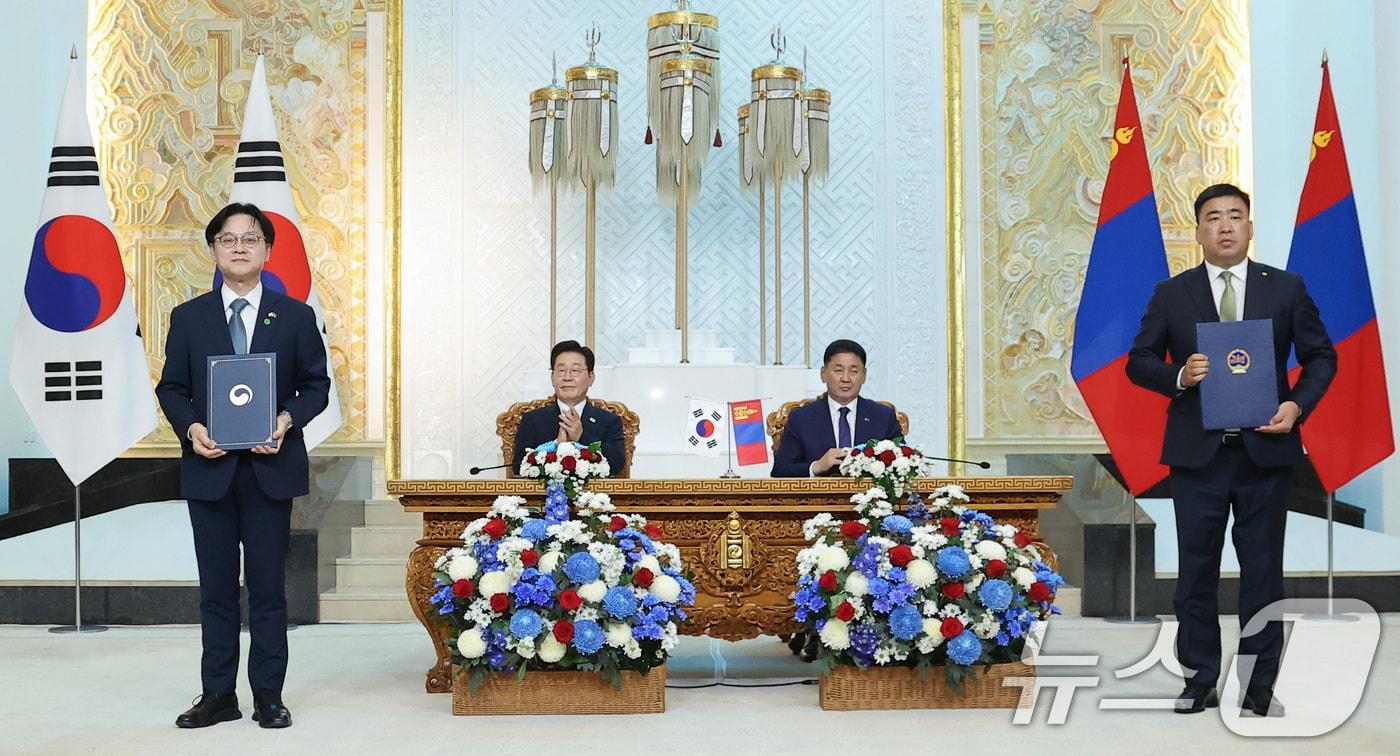 본문 이미지 - 김정관 산업통상부 장관과 차강후 이데르바트 몽골 식량농업경공업부 장관이 9일(현지시간) 울란바타르 정부청사에서 이재명 대통령과 오흐나 후렐수흐 몽골 대통령이 임석한 가운데 유통·물류 협력을 위한 양해각서(MOU)를 체결한 뒤 기념촬영을 하고 있다. 2026.7.9 ⓒ 뉴스1 이재명 기자