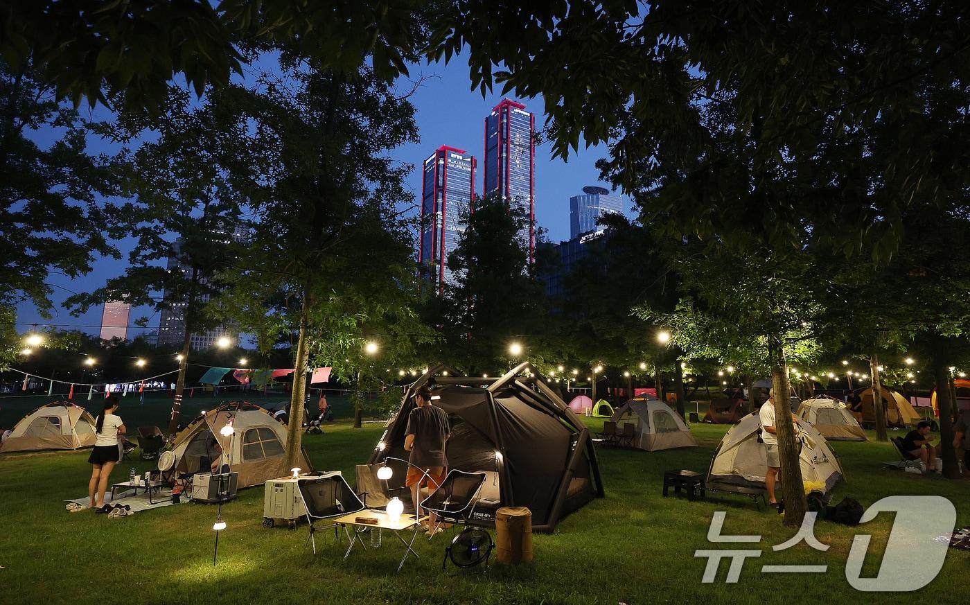 본문 이미지 - 1일 오후 서울 여의도한강공원에서 시민들이 '한강 밤핑(Night+Camping)'을 즐기고 있다. 한강 밤핑은 시민들이 한강 야경을 바라보며 하룻밤을 보낼 수 있도록 마련한 도심 속 임시 야영장이다. 여의도한강공원 물빛무대 앞 잔디밭과 뚝섬한강공원 잔디밭에서 이날부터 8월 한달간 매일 오후 5시부터 다음날 오전 9시까지 운영된다. 2026.8.1 ⓒ 뉴스1 박지혜 기자