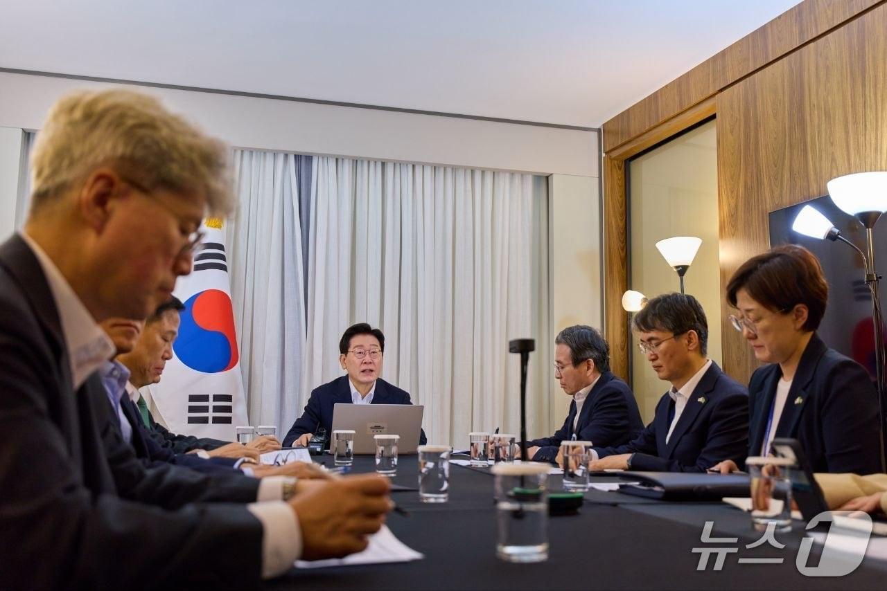 본문 이미지 - 브라질을 국빈방문한 이재명 대통령이  지난달 29일 브라질리아에서 화상 수석보좌관회의를 주재하는 모습. 왼쪽이 김상호 춘추관장.