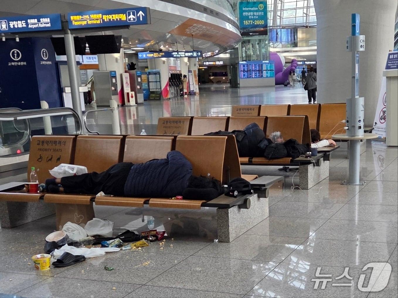 본문 이미지 - 인천국제공항 여객터미널에서 장기 체류 중인 노숙인이 의자에 누워 휴식을 취하고 있다.(독자 제공)2026.8.10/뉴스1