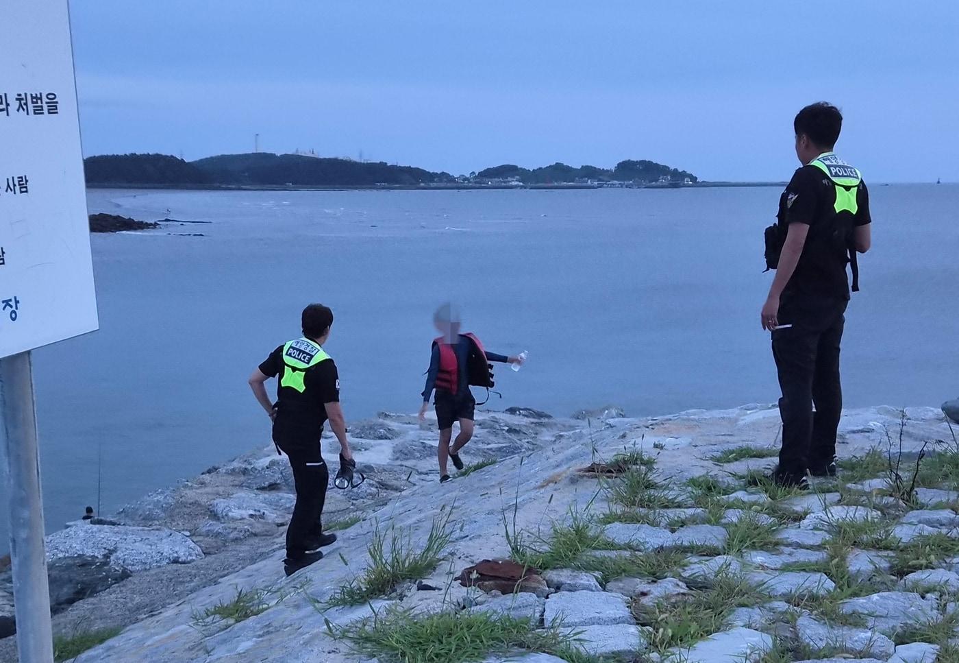 본문 이미지 - 해상에서 구조된 10대 A 군을 해경이 인계받고 있다.(보령해경 제공. 재판매 및 DB금지)/뉴스1