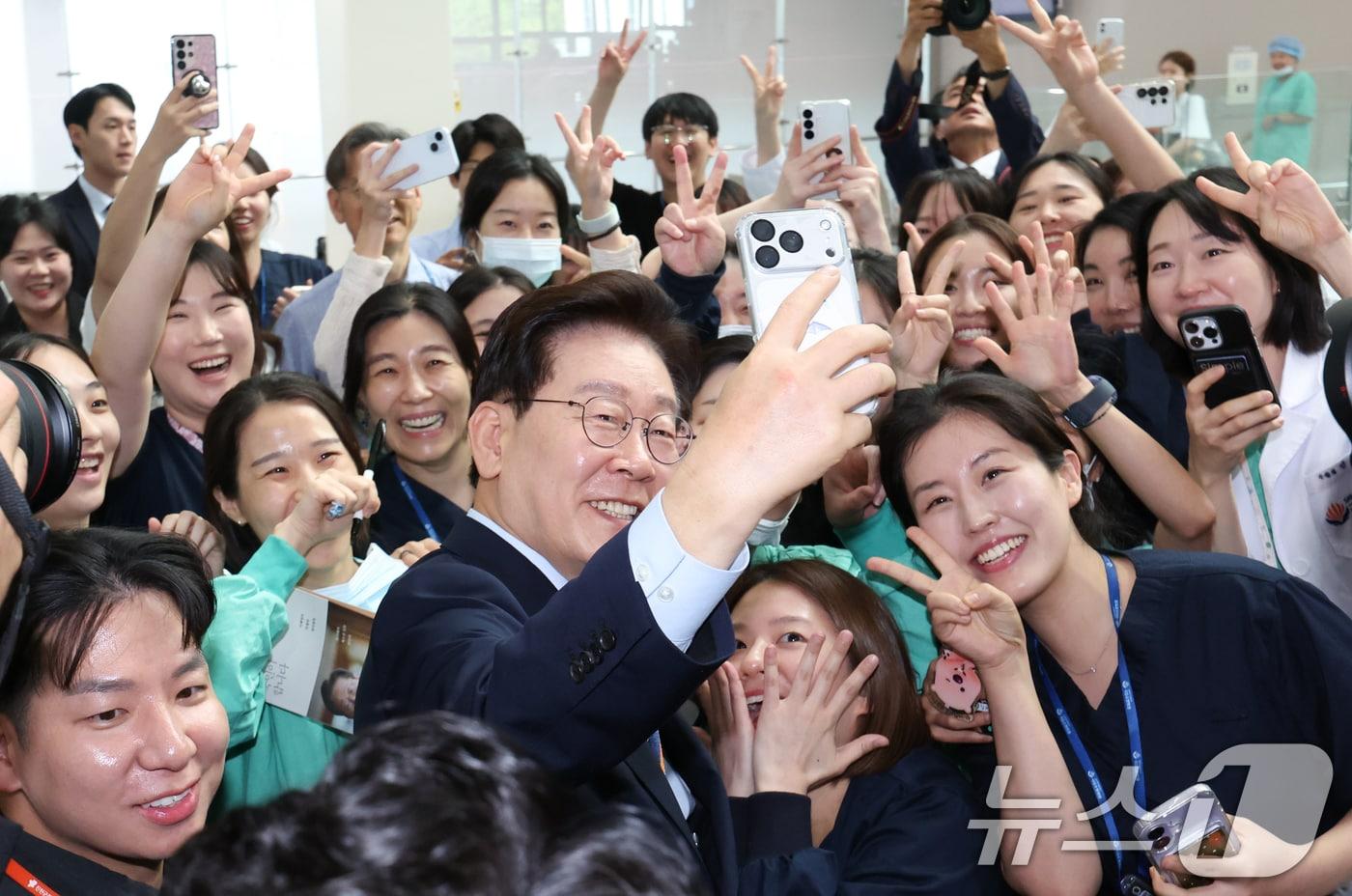 본문 이미지 - 이재명 대통령이 11일 충북 음성군 국립소방병원에서 열린 개원식을 마친 후 의료진과 기념촬영을 하고 있다. 2026.8.11 ⓒ 뉴스1 이재명 기자