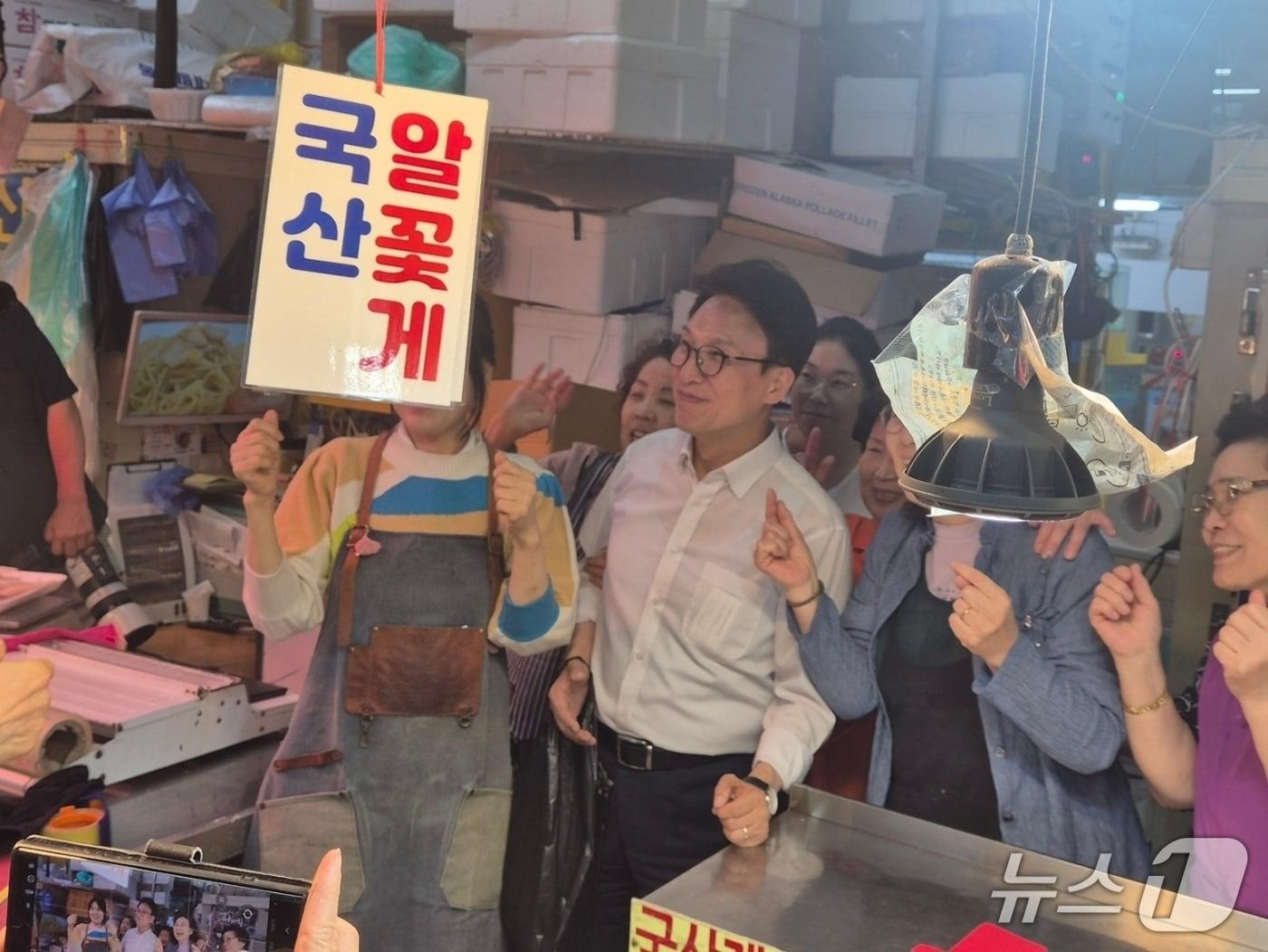 본문 이미지 -  11일 오후 더불어민주당 전당대회 당대표 선거에 출마한 김민석 후보가 서울 송파구 가락시장을 찾아 시민들의 사진 요청에 화답하고 있다. ⓒ 뉴스1 남해인 기자