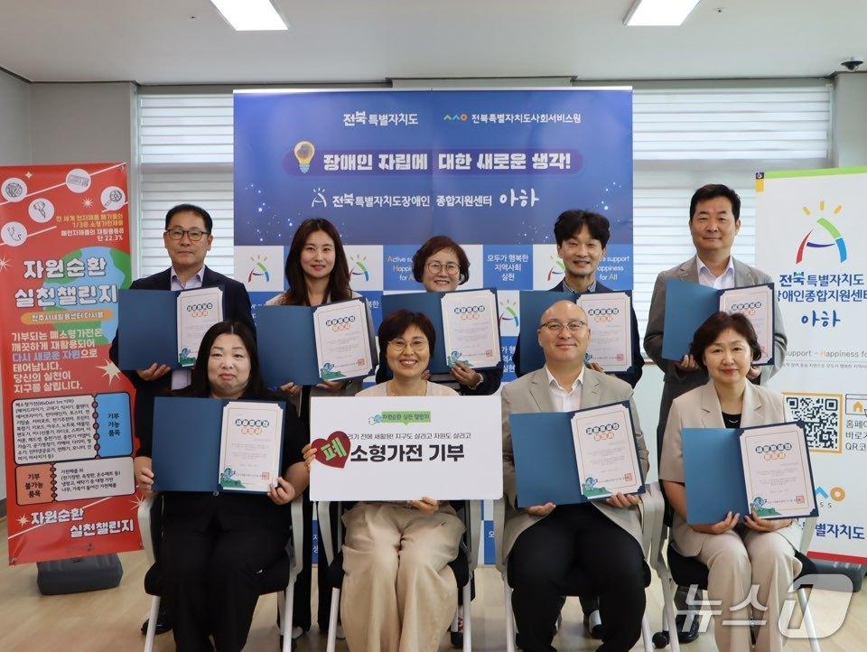 본문 이미지 - 전북사회서비스원이 '폐소형가전·폐우산 기부 챌린지'를 추진한 가운데 관계자들이 기념 촬영을 하고 있다.(전북사회서비스원 제공. 재판매 및 DB금지)/뉴스1