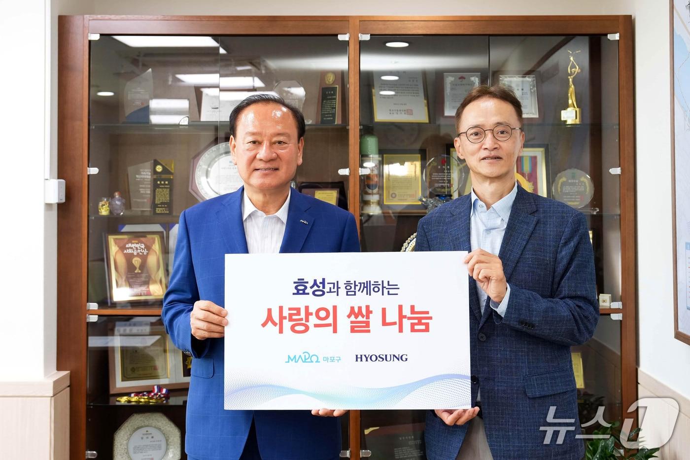 본문 이미지 - 효성은 11일 서울 마포구청에서 사랑의 쌀 전달식을 열고 20kg 쌀 500포대를 전달했다고 밝혔다. 사진은 유동균 마포구청장(왼쪽)과 이정원 효성 전무가 쌀 전달식을 진행하는 모습. (효성 제공)