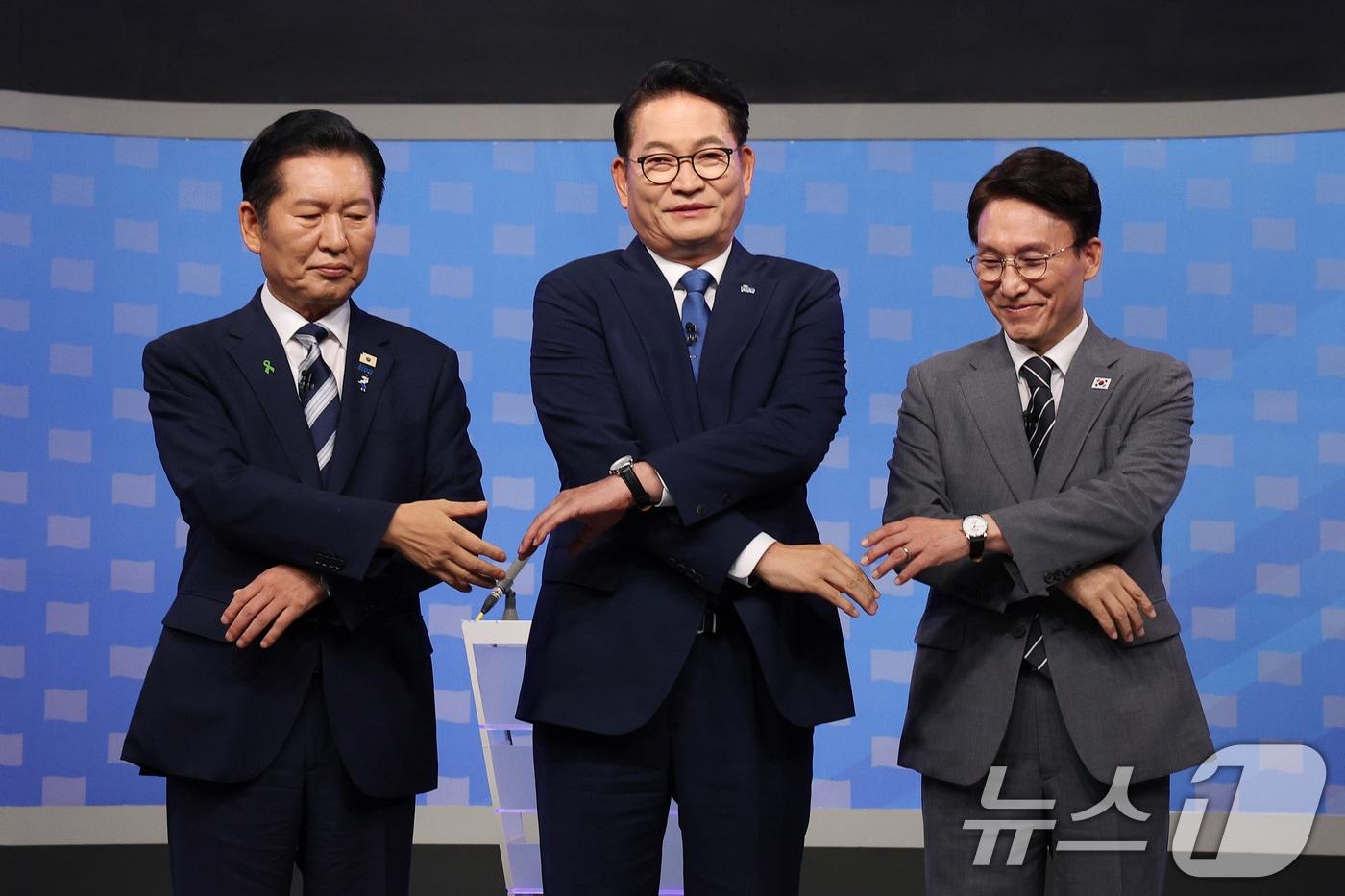 본문 이미지 - 더불어민주당 정청래(왼쪽부터), 송영길, 김민석 당대표 후보가 12일 서울 양천구 목동 SBS에서 열린 당대표 후보자 토론회에 앞서 기념 촬영을 위해 손을 맞잡고 있다. 2026.8.12 ⓒ 뉴스1 국회사진기자단