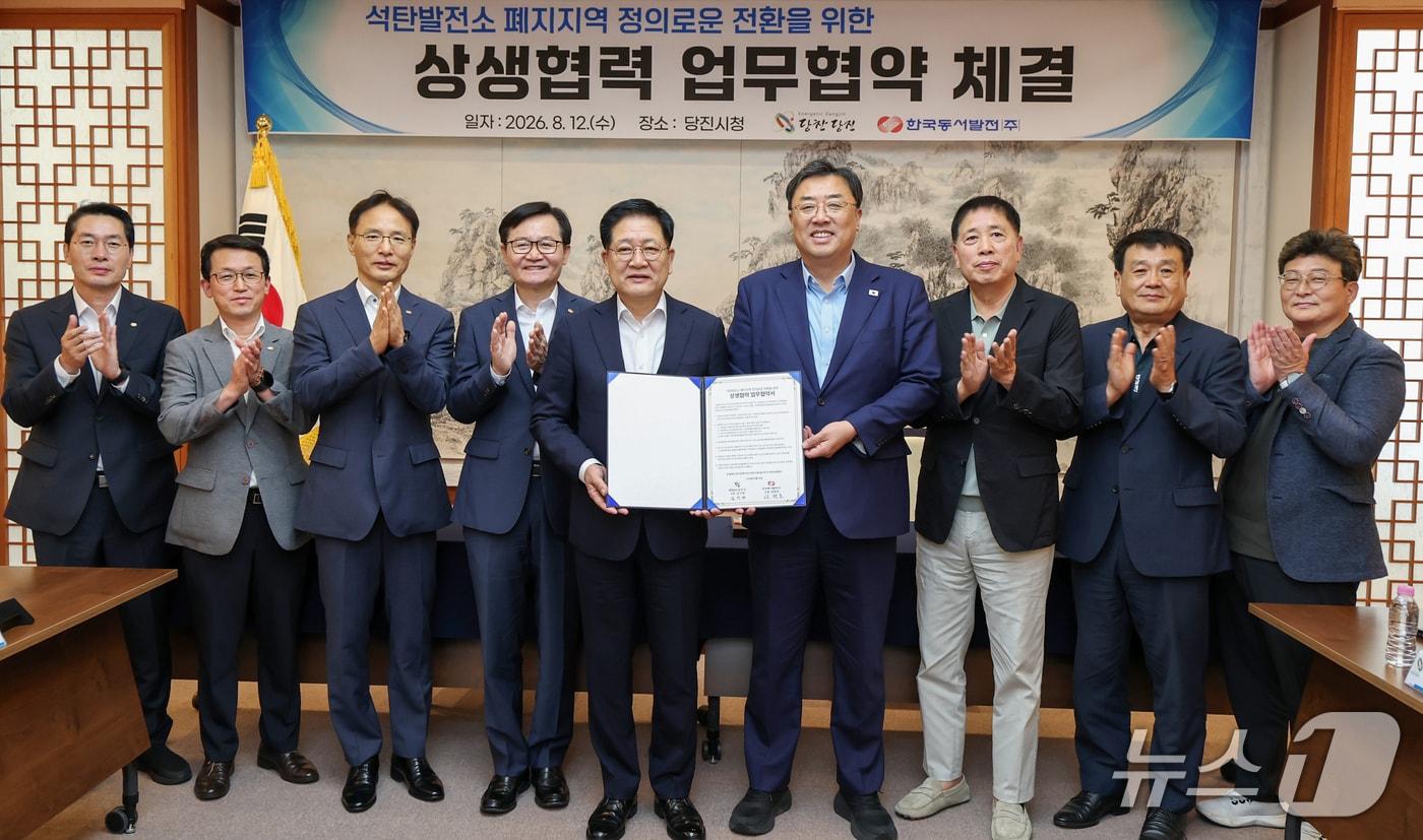 본문 이미지 - 권명호 한국동서발전 사장(왼쪽 다섯번째)과 김기재 충남 당진시장(오른쪽 네번째)이 12일 당진시청에서 석탄발전소 폐지지역 정의로운 전환을 위한 상생협력 업무협약식을 갖고 참석자들과 기념촬영하고 있다. 2026.8.12(동서발전 제공. 재판매 및 DB 금지) /뉴스1