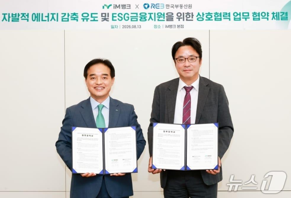 본문 이미지 - 최상수 iM뱅크 기관영업그룹 부행장(왼쪽)과 이정환 한국부동산원 산업지원본부장이 '자발적 에너지 감축 유도 및 ESG 금융지원'을 위한 업무협약을 체결한 뒤 협약서를 펼쳐 보이고 있다.(iM뱅크 제공, 재판매 및 DB 금지)