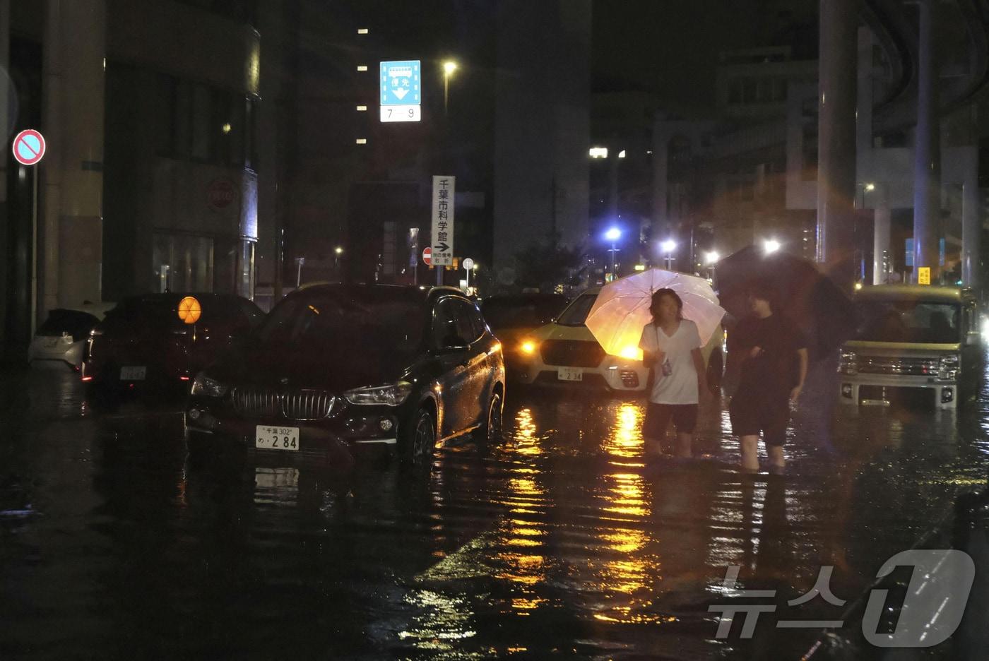 본문 이미지 - 기록적인 폭우가 내린 일본 지바현 지바시에서 14일 주민들이 물에 잠긴 도로를 걷고 있다. (교도통신 제공) ⓒ 로이터=뉴스1