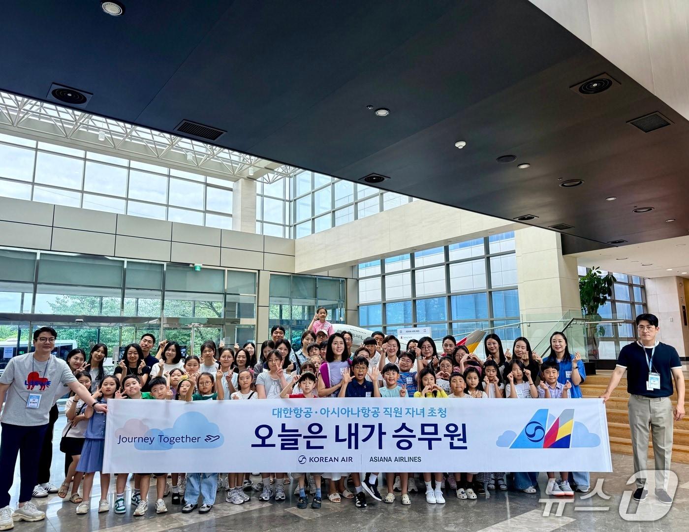 본문 이미지 - 13일 서울 강서구 아시아나항공 객실훈련원에서 '오늘은 내가 승무원' 진로 교육에 참가한 아시아나항공·대한항공 직원 자녀들이 기념사진을 촬영하고 있다(아시아나항공 제공)