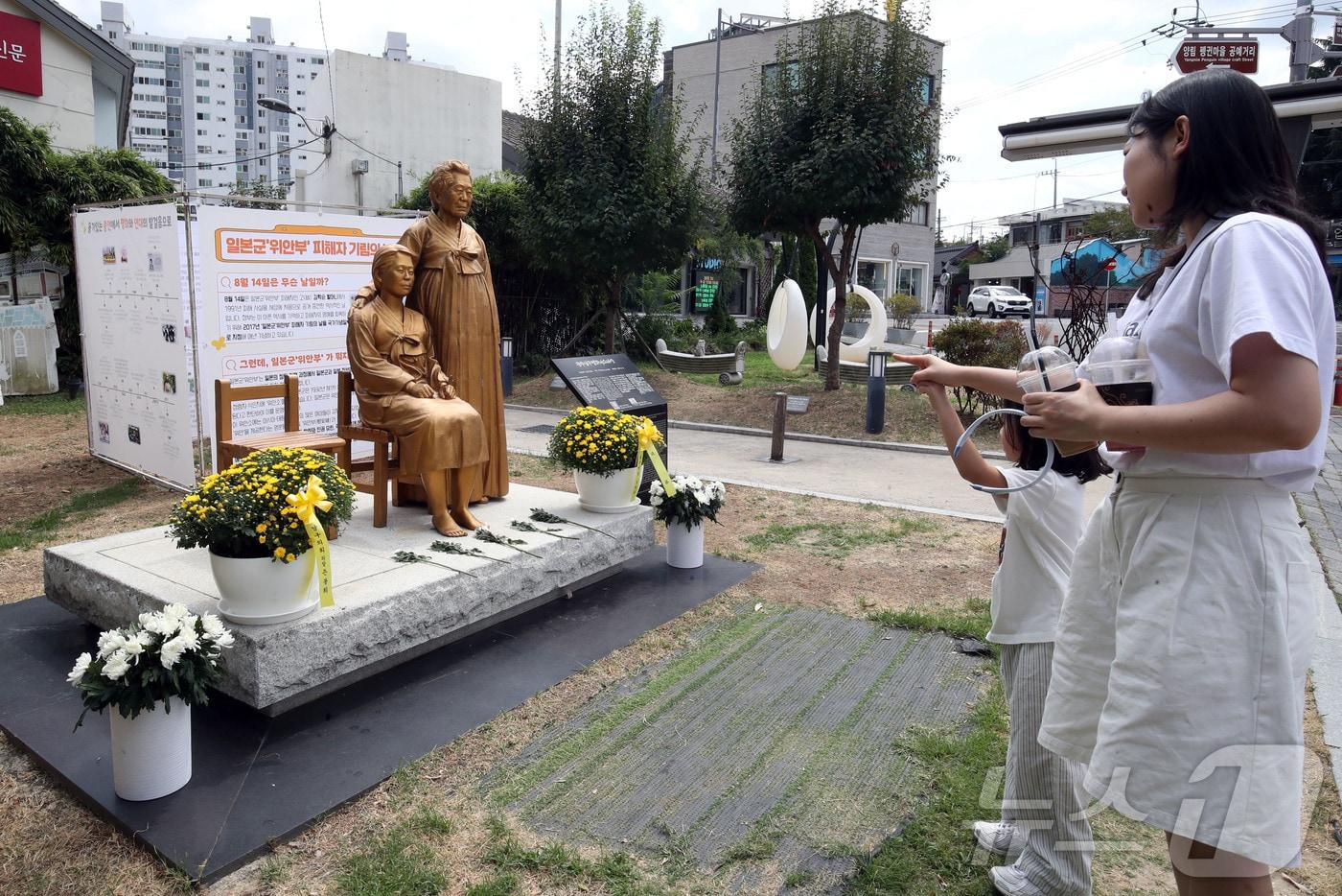 본문 이미지 - 제81주년 광복절을 하루 앞둔 14일 전남광주 남구 양림동 근대역사문화마을에서 딸이랑 같이 온 시민이 남구 평화의 소녀상을 보고 있다. 2026.8.14 ⓒ 뉴스1 조수민 기자