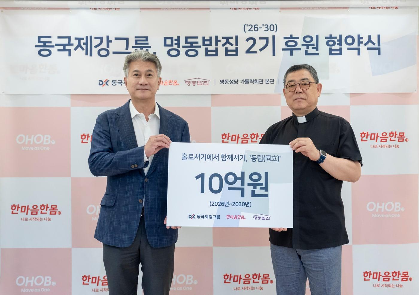 본문 이미지 - 장세욱 동국제강그룹 부회장(왼쪽)과 백광진 명동밥집 센터장(신부)가 서울 중구 을지로 본사 페럼타워에서 '2기 후원 협약식'을 갖고 기념사진촬영을 하고 있다. 2026.8.14(동국제강그룹 제공)