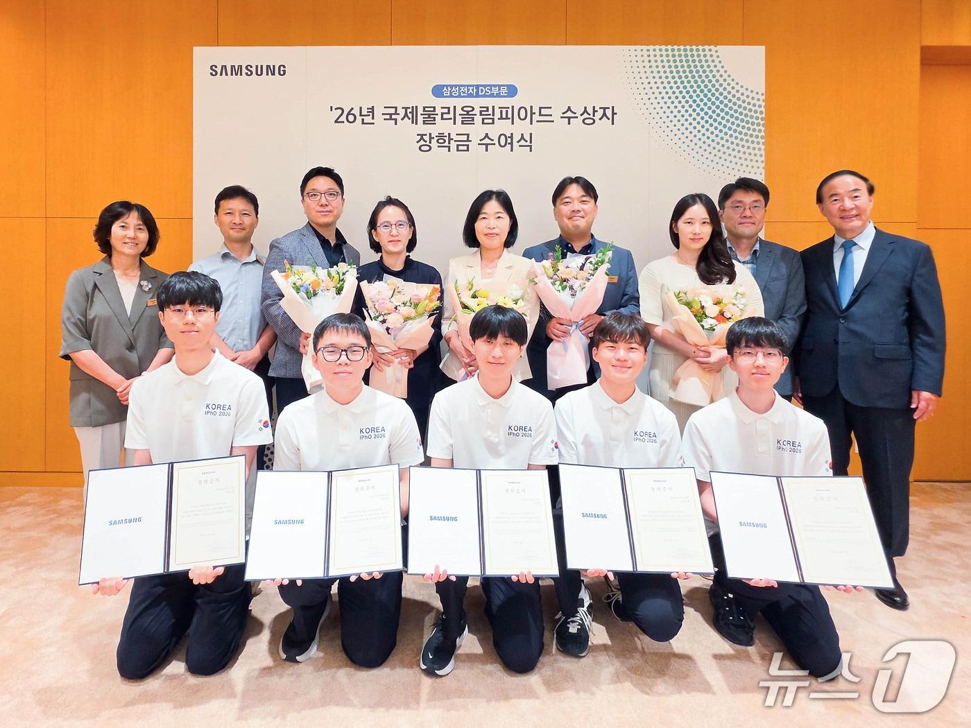 본문 이미지 - 전영현 삼성전자 DS 부문장(뒷줄 오른쪽)과 윤진희 한국물리학회장(뒷줄 왼쪽), 올해 국제물리올림피아드 수상자들과 학부모 등이 지난 13일 삼성전자 화성캠퍼스에서 열린 장학금 수여식에 참석해 기념촬영하고 있다(삼성전자 제공)