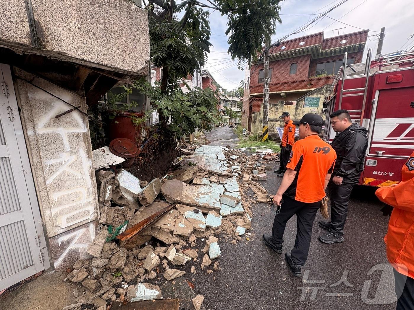 본문 이미지 - 호우주의보가 발효 중이던 17일 오전 11시 25분 울산 중구 교동의 한 주택가 담벼락이 무너져 소방대원들이 조치하고 있다.(울산소방본부 제공. 재판매 및 DB금지)ⓒ 뉴스1