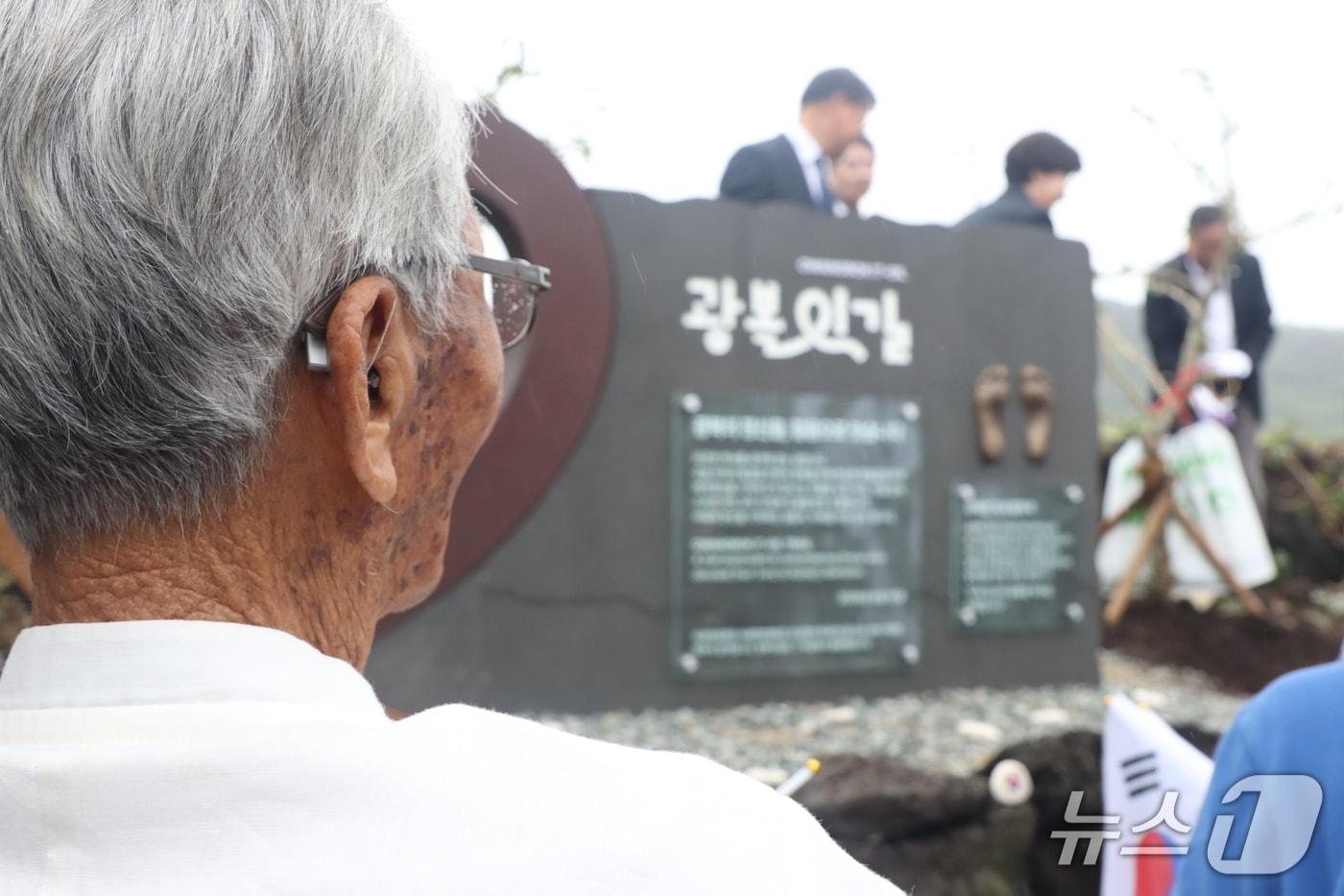 본문 이미지 - 강태선 애국지사가 '광복잇길 기림비'를 바라보고 있다.(자생한방병원 제공)