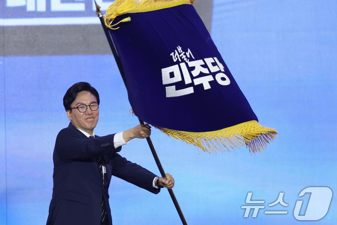 본문 이미지 - 김민석 신임 더불어민주당 대표가 17일 오후 대전 유성구 DCC대전컨벤션센터에서 열린 '더불어민주당 제3차 정기전국당원대회'에서 당기를 흔들고 있다. 2026.8.17 ⓒ 뉴스1 황기선 기자
