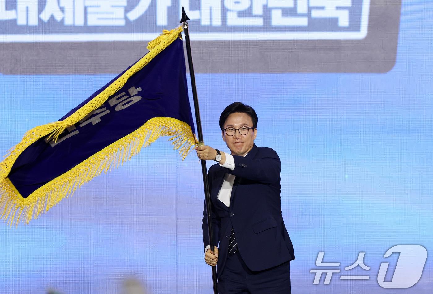 본문 이미지 - 김민석 신임 더불어민주당 대표가 17일 오후 대전 유성구 DCC대전컨벤션센터에서 열린 '더불어민주당 제3차 정기전국당원대회'에서 당기를 흔들고 있다. 2026.8.17 ⓒ 뉴스1 황기선 기자