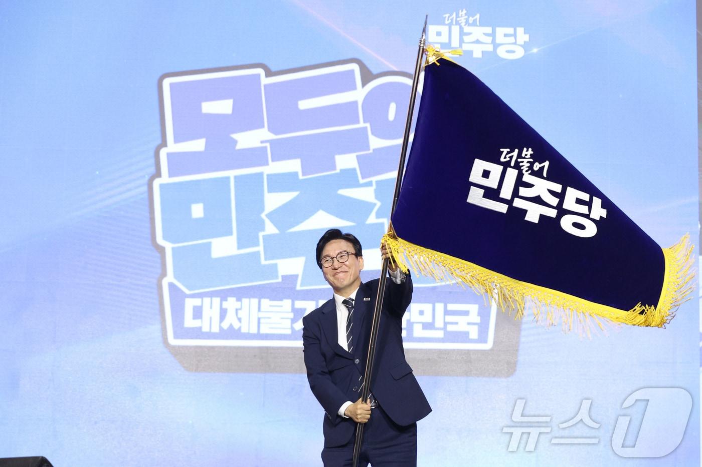 본문 이미지 - 김민석 신임 더불어민주당 대표가 17일 오후 대전 유성구 DCC대전컨벤션센터에서 열린 '더불어민주당 제3차 정기전국당원대회'에서 당기를 흔들고 있다. (공동취재) 2026.8.17 ⓒ 뉴스1 황기선 기자