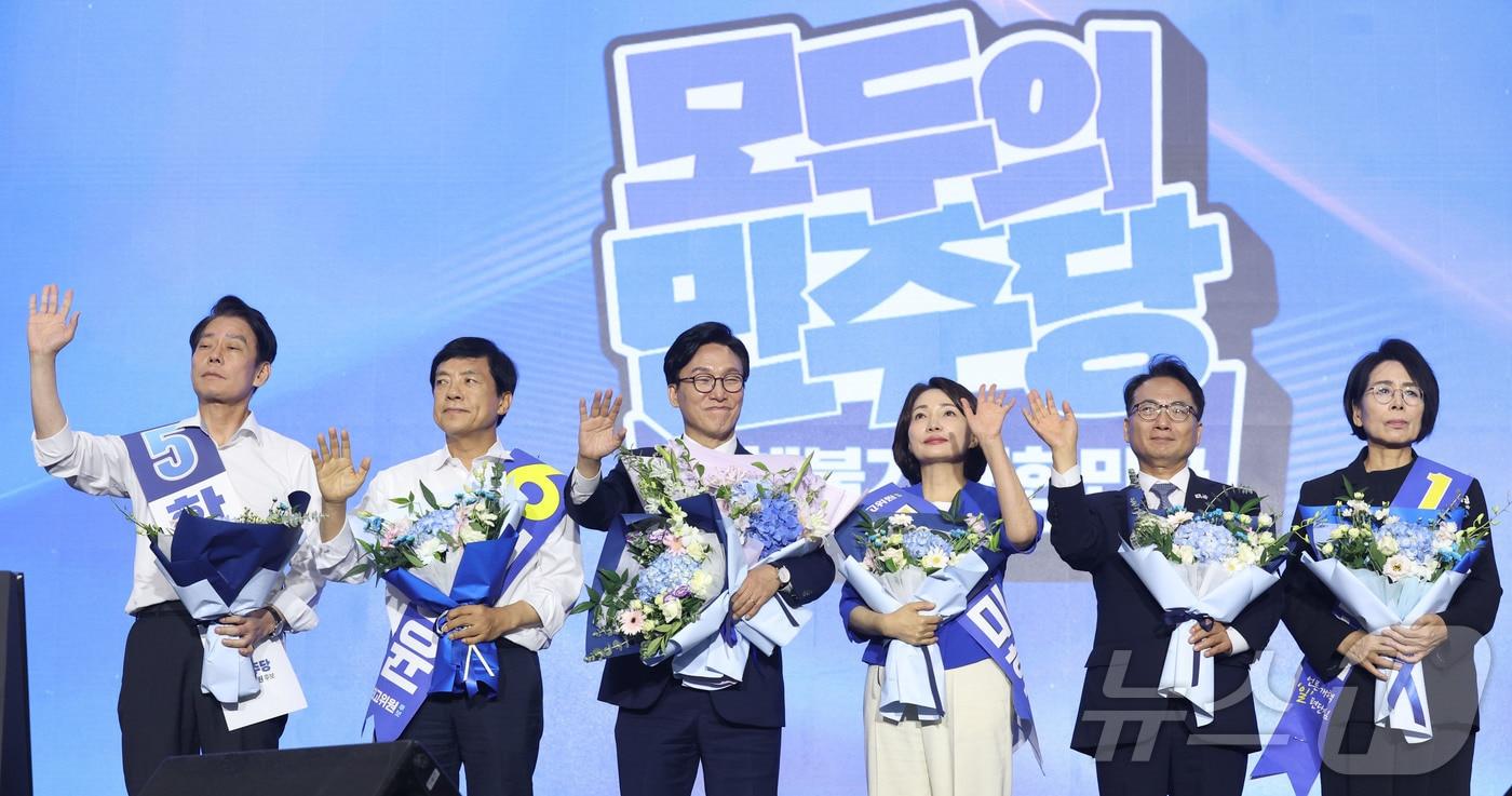 본문 이미지 - 김민석 더불어민주당 신임 당대표와 최고위원들이 17일 오후 대전 유성구 DCC대전컨벤션센터에서 열린 '더불어민주당 제3차 정기전국당원대회'에서 손을 들어 인사하고 있다. 왼쪽부터 한민수, 이성윤, 김 대표, 서미화, 박선원, 최민희 최고위원. (공동취재) 2026.8.17 ⓒ 뉴스1 황기선 기자