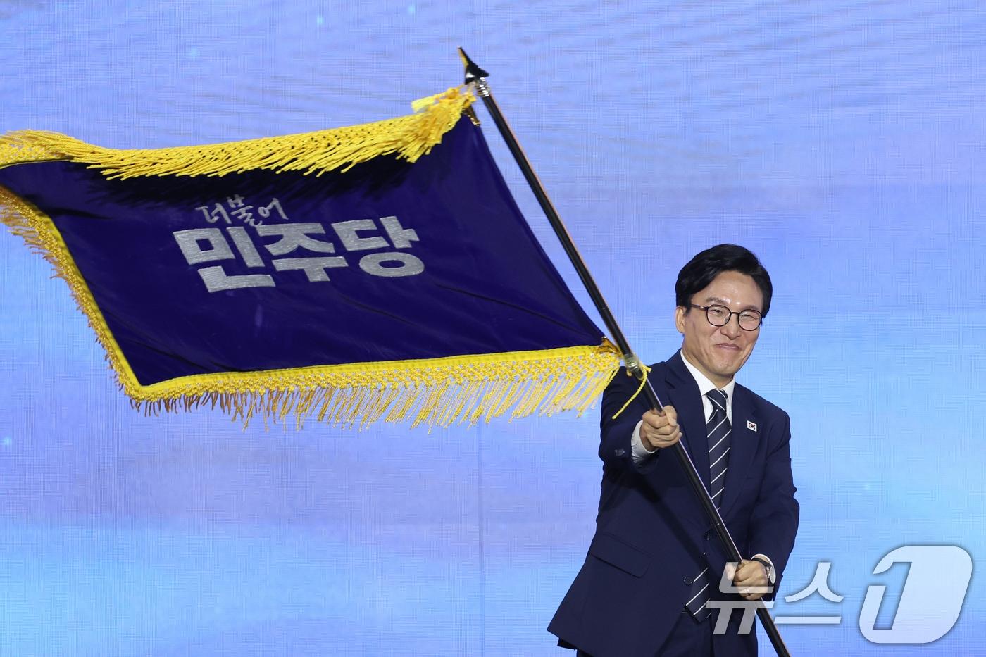 본문 이미지 - 김민석 신임 더불어민주당 대표가 17일 오후 대전 유성구 DCC대전컨벤션센터에서 열린 '더불어민주당 제3차 정기전국당원대회'에서 당기를 흔들고 있다. 2026.8.17 ⓒ 뉴스1 황기선 기자
