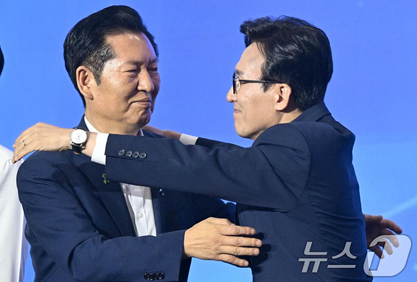 본문 이미지 - 김민석 더불어민주당 신임 당대표가 17일 대전시 유성구 대전컨벤션센터에서 열린 더불어민주당 제3차 정기전국당원대회에서 정청래 후보와 포옹하고 있다. (공동취재) 2026.8.17 ⓒ 뉴스1 황기선 기자