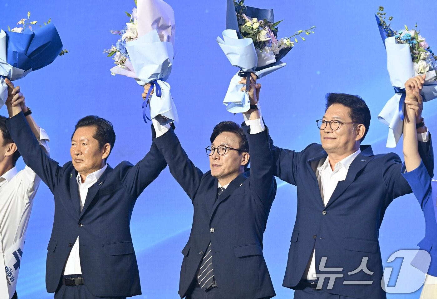 본문 이미지 - 김민석 더불어민주당 신임 대표가 17일 대전 컨벤션센터에서 열린 제3회 더불어민주당 정기 전국당원대회에서 당 대표 당선이 확정되자 정청래, 송영길 후보와 꽃다발을 들고 인사를 하고 있다. 2026. 08. 17. 2026.8.17 ⓒ 뉴스1 황기선 기자