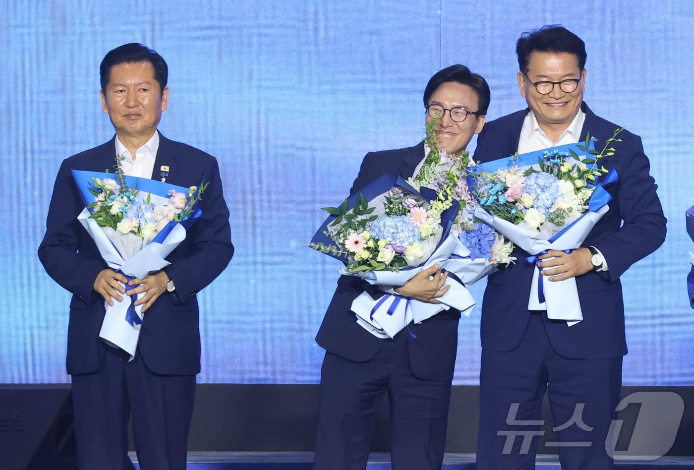 본문 이미지 - 김민석 더불어민주당 신임 대표가 17일 대전 유성구 대전컨벤션센터(DCC) 제2전시장에서 열린 제3차 정기전국당원대회에서 정청래, 송영길 후보와 꽃다발을 받고 기념촬영을 하고 있다. (공동취재) 2026.8.17 ⓒ 뉴스1 황기선 기자
