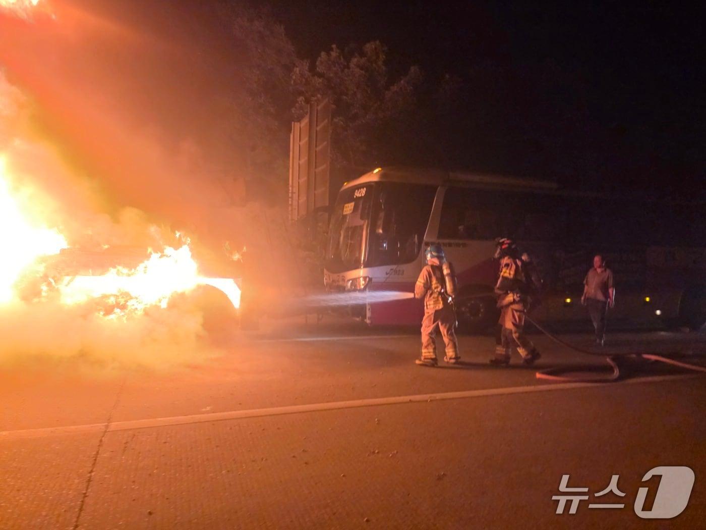 본문 이미지 - 18일 오전 2시 30분쯤 경북 구미시 옥성면 중부내륙고속도로 창원 방향 선산휴게소 인근에서 사고로 파손된 대형 버스를 견인해 가던 견인차에서 불이 나 진화 대원들이 불을 끄고 있다.(송영훈씨 제공. 재판매 및 DB 금지)2026.8.18/뉴스1