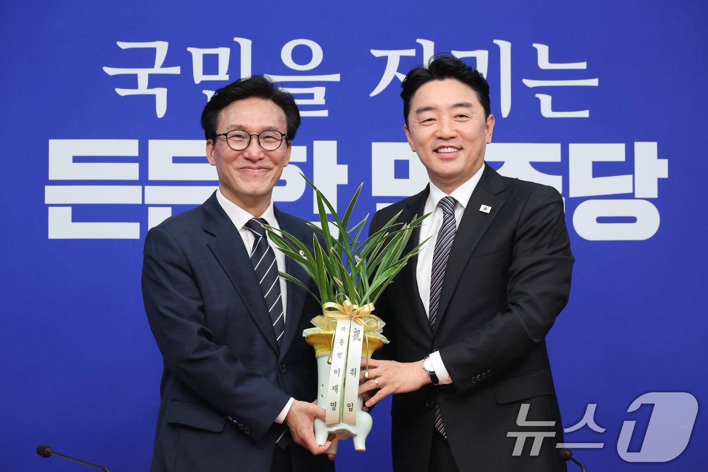 본문 이미지 - 김민석 더불어민주당 대표가 18일 서울 여의도 국회를 찾은 강훈식 대통령 비서실장으로부터 이재명 대통령의 당선 축하난을 전달받고 있다. 2026.8.18 ⓒ 뉴스1 신웅수 기자