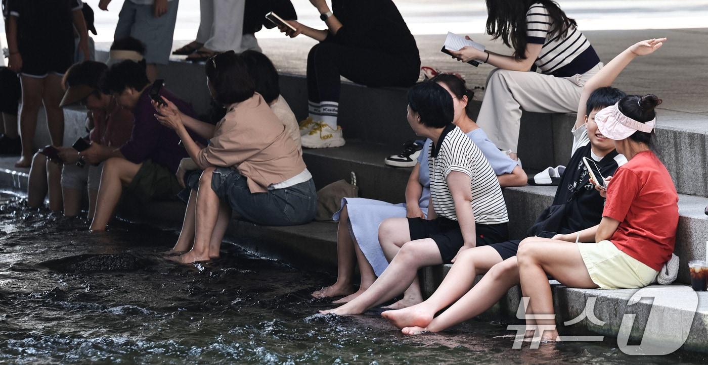 본문 이미지 - 서울 일부 지역에 폭염주의보가 다시 발효된 18일 서울 청계천에서 시민들이 휴식을 취하고 있다. 이날 서울의 낮 최고기온은 32도까지 오르고 높은 습도로 최고체감온도는 33도 안팎을 보일 것으로 예보됐다. 2026.8.18 ⓒ 뉴스1 이종수 기자