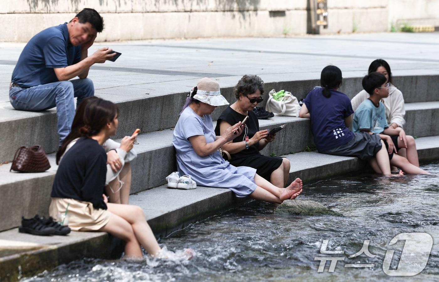 본문 이미지 - 서울 일부 지역에 폭염주의보가 다시 발효된 18일 서울 청계천에서 시민들이 휴식을 취하고 있다. 이날 서울의 낮 최고기온은 32도까지 오르고 높은 습도로 최고체감온도는 33도 안팎을 보일 것으로 예보됐다. 2026.8.18 ⓒ 뉴스1 이종수 기자