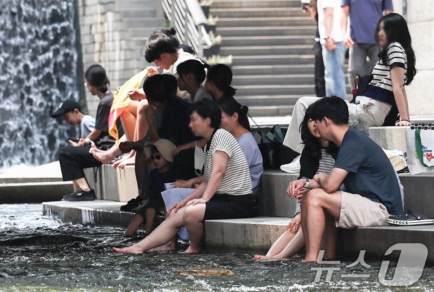 본문 이미지 - 서울 일부 지역에 폭염주의보가 다시 발효된 18일 서울 청계천에서 시민들이 휴식을 취하고 있다. 이날 서울의 낮 최고기온은 32도까지 오르고 높은 습도로 최고체감온도는 33도 안팎을 보일 것으로 예보됐다. 2026.8.18 ⓒ 뉴스1 이종수 기자
