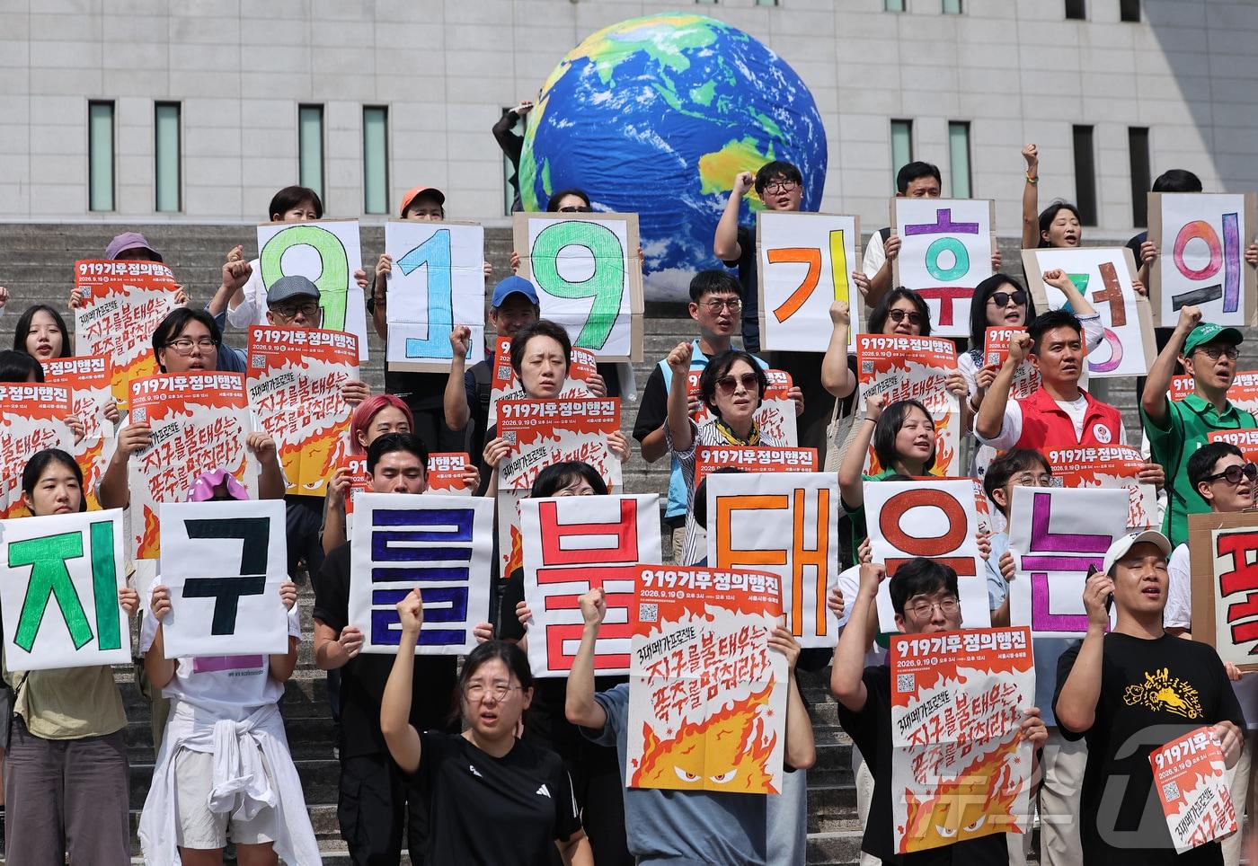 본문 이미지 - 9·19기후정의행진 조직위원회 관계자들이 19일 서울 종로구 세종문화회관 계단에서 열린 '지구를 불태우는 폭주를 멈춰라' 선포식에서 퍼포먼스를 하고 있다. 2026.8.19 ⓒ 뉴스1 김성진 기자