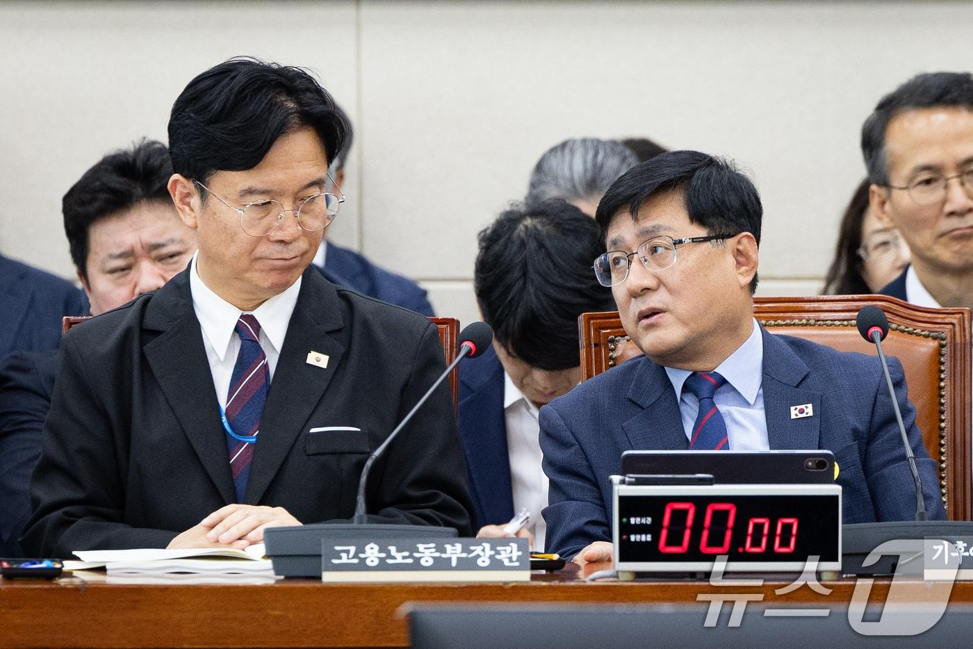 본문 이미지 - 김성환 기후에너지환경부 장관(오른쪽)과 김영훈 고용노동부 장관이 19일 서울 여의도 국회에서 열린 제438회 국회(임시회) 기후에너지환경노동위원회 제3차 전체회의에 출석해 대화하고 있다. 2026.8.19 ⓒ 뉴스1 유승관 기자