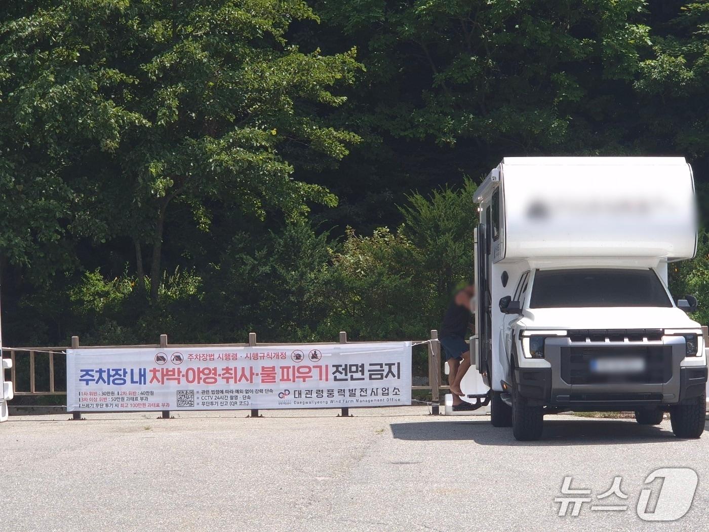 본문 이미지 - 2일 '캠핑 성지' '차박 성지'로 불리는 강원 평창군 대관령 옛 영동고속도로 대관령 휴게소 강릉 방면 공터. '차박 금지'를 알리는 현수막 앞에 캠핑카가 주차돼 있다. 2026.8.2/뉴스1 윤왕근 기자