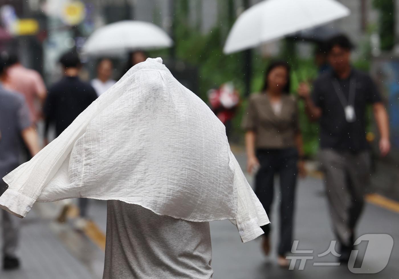 본문 이미지 - 비가 내린 20일 오후 서울 중구 명동거리에서 시민이 외투를 머리에 쓴 채 발걸음을 옮기고 있다. 2026.8.20 ⓒ 뉴스1 김민지 기자