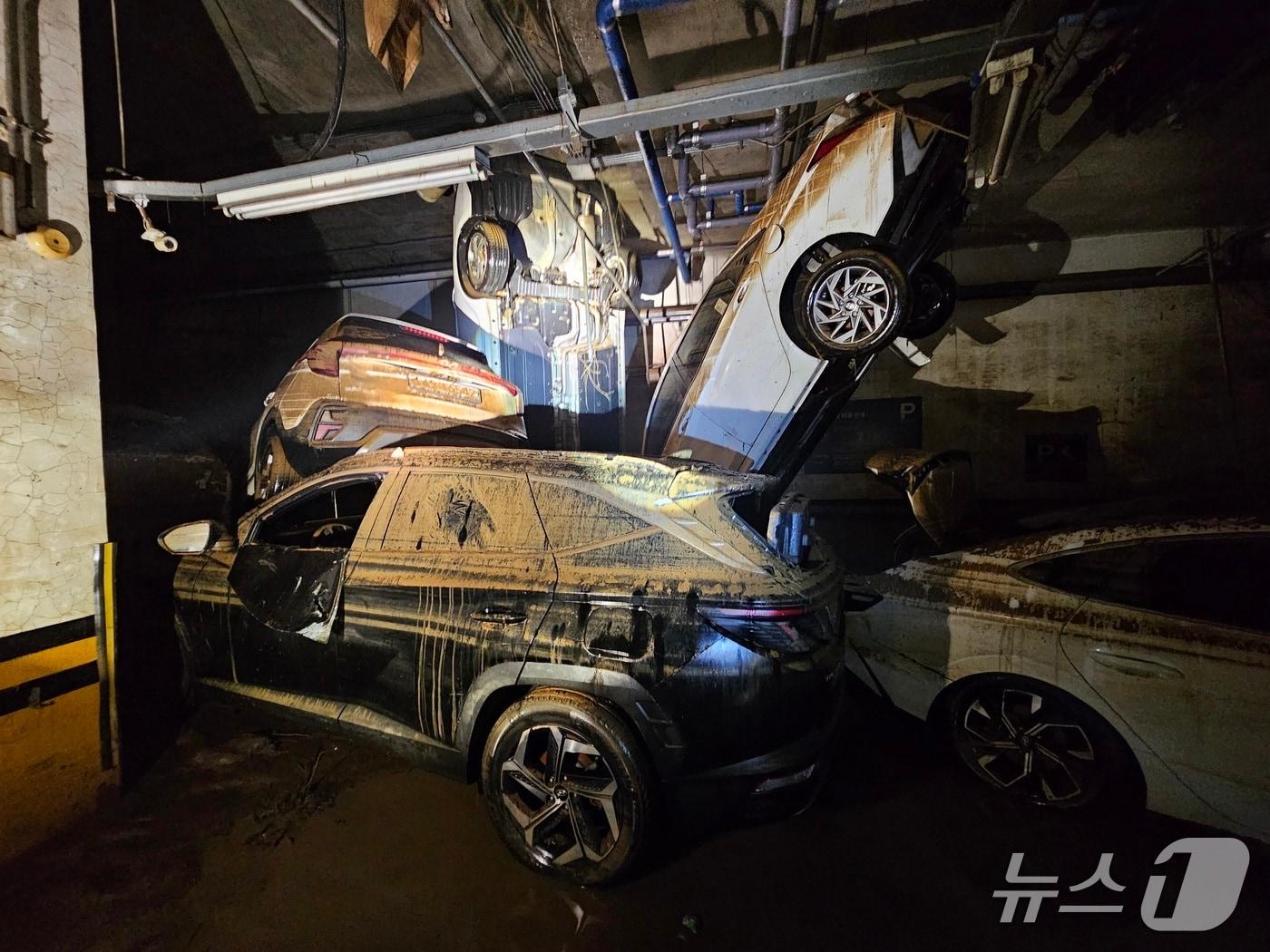 본문 이미지 - 거제시 고현동의 한 상가건물 주차장에 주차된 차들이 침수피해를 입어 차들이 뒤엉켜 있다. 2026.8.20/뉴스1 한송학기자