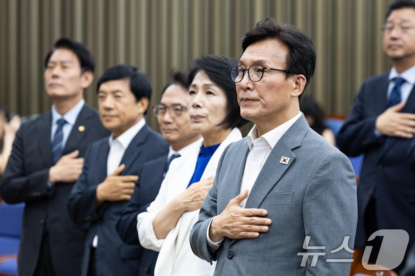 본문 이미지 - 김민석 더불어민주당 대표를 비롯한 의원들이 20일 서울 여의도 국회에서 열린 의원총회에서 국민의례를 하고 있다. 2026.8.20 ⓒ 뉴스1 유승관 기자