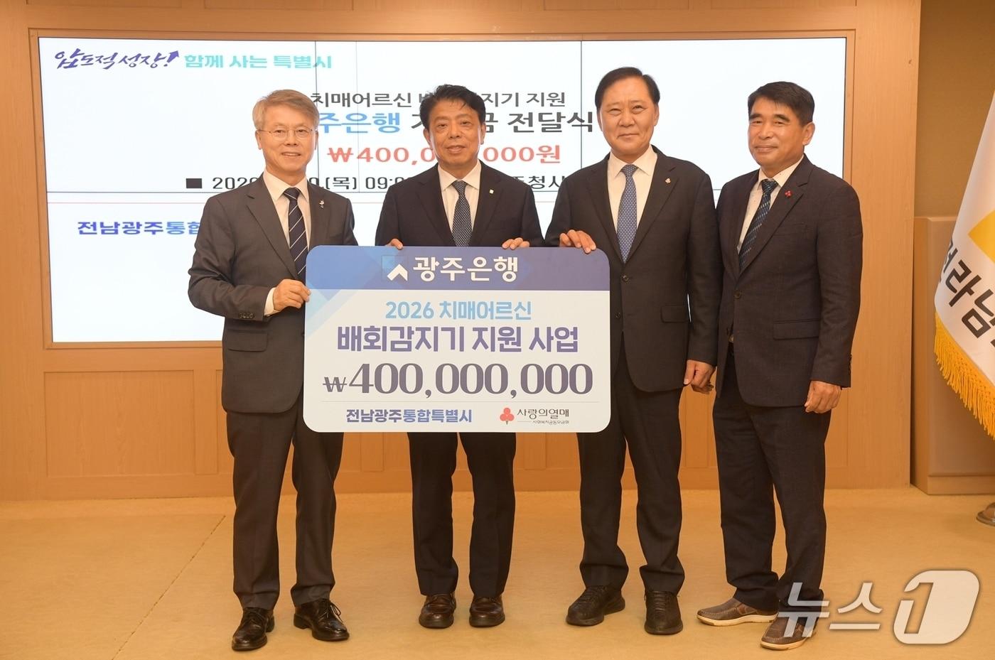 본문 이미지 - 민형배 전남광주통합특별시장이 20일 광주청사 비즈니스룸에서 정일선 광주은행장으로부터 치매어르신 스마트워치 및 스마트태그 지원을 위한 기부금을 전달받은 후 기념촬영을 하고 있다.(사진=전남광주통합특별시 제공)